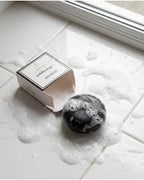 Moringa Shampoo Bar viser botanisk dybderens. Aktivt kul absorberer sebum, mens moringaolie genopbygger håret uden brug af sulfater og silikone.